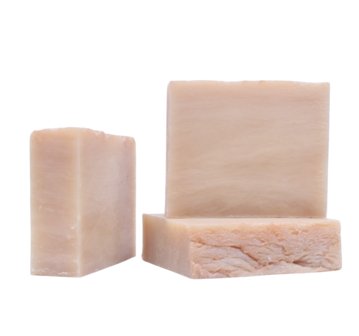 Three bars of beige soap on a white background
