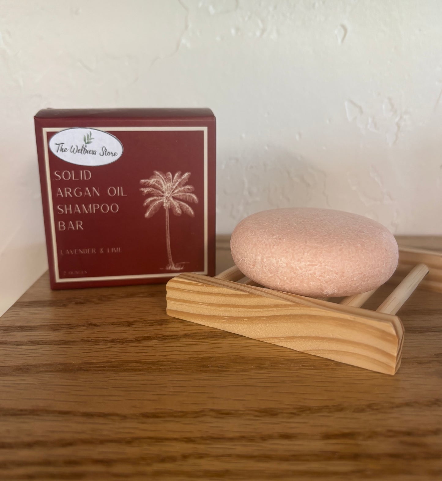 Solid argan oil shampoo bar with packaging on a wooden surface