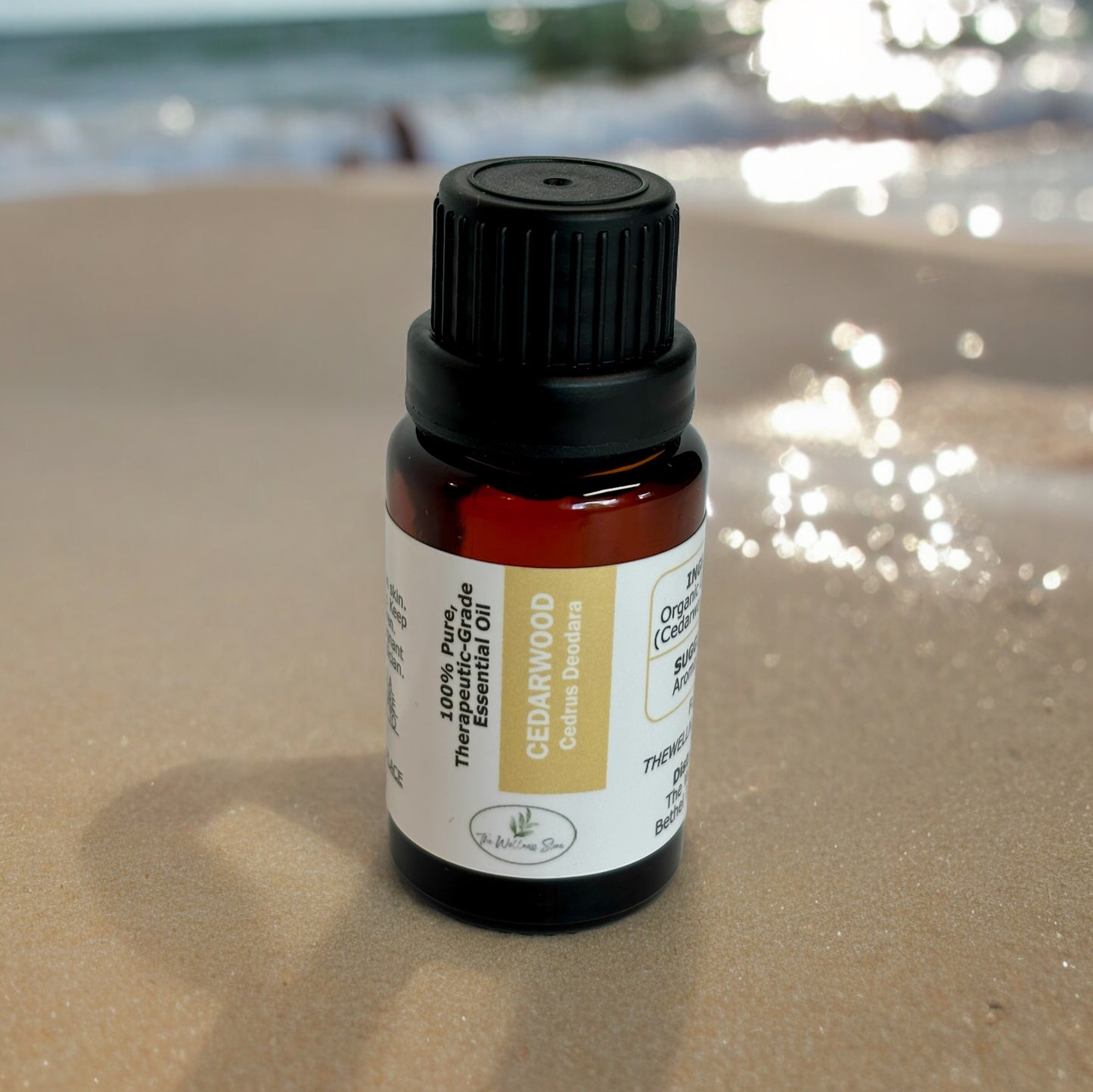 Cedarwood essential oil on sand with water in the background