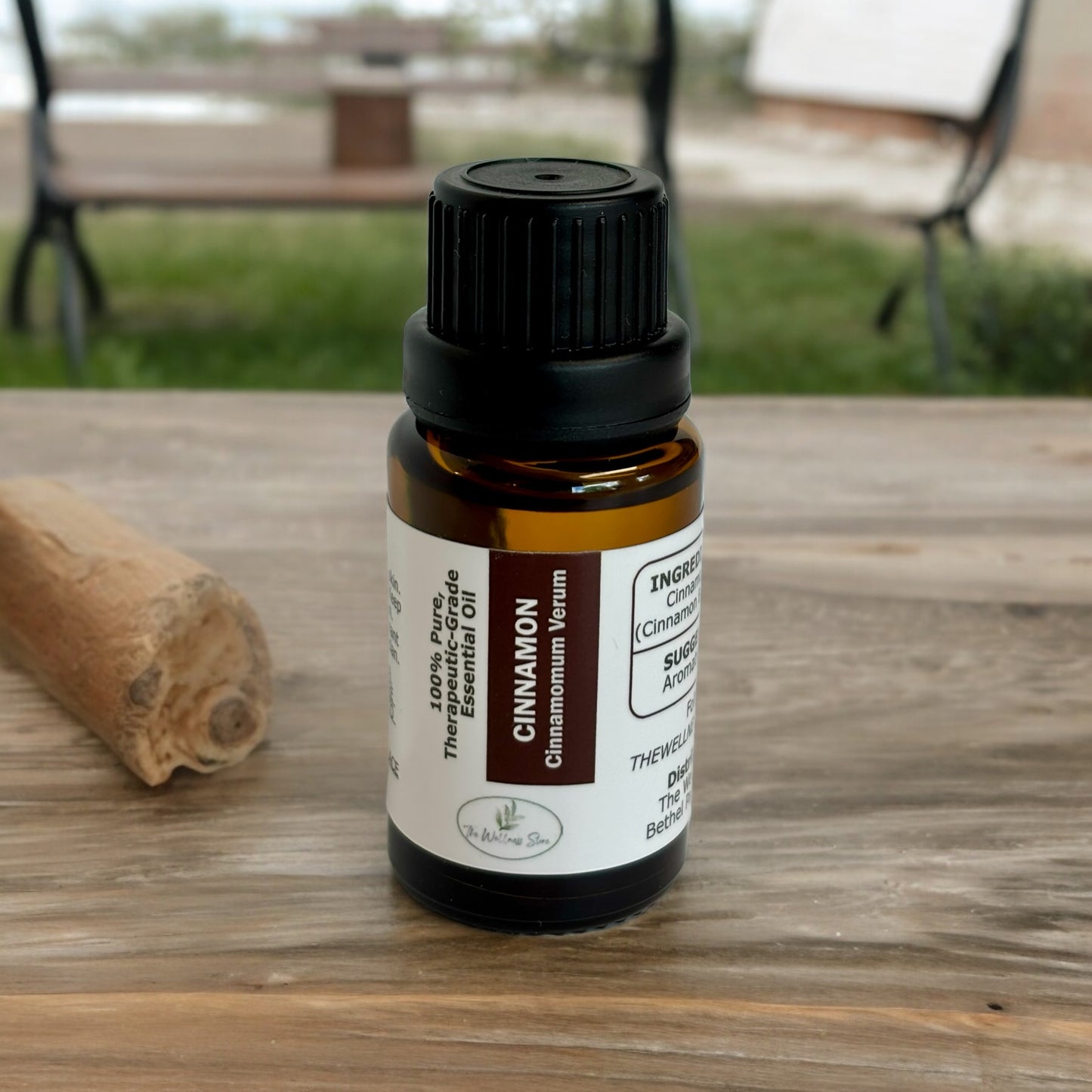Essential oil on a wood table with a bench on the grass in the background