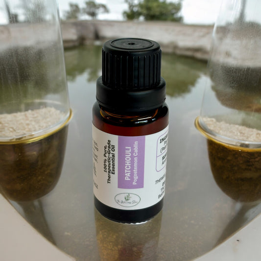 Patchouli essential oil on a water pond with glass jars in the background