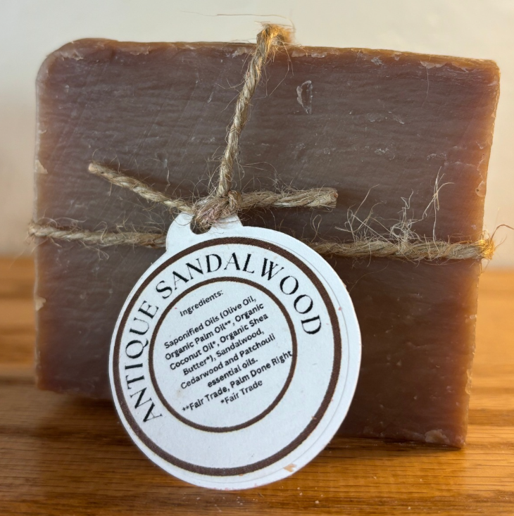 Bar of antique sandalwood soap with a label on a wooden surface