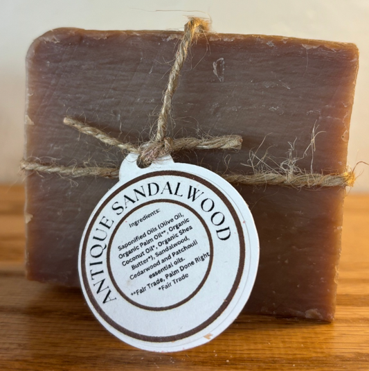 Bar of antique sandalwood soap with a label on a wooden surface
