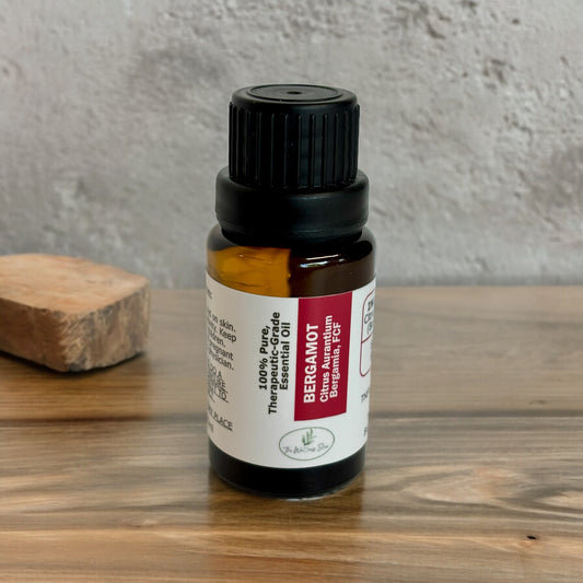Bergamot Essential Oil on a wood table with a concrete looking background