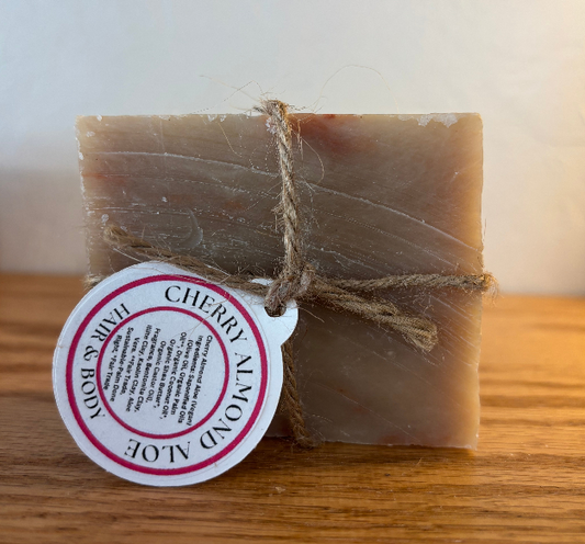 Bar of soap with a cherry almond aloe label on a wooden surface