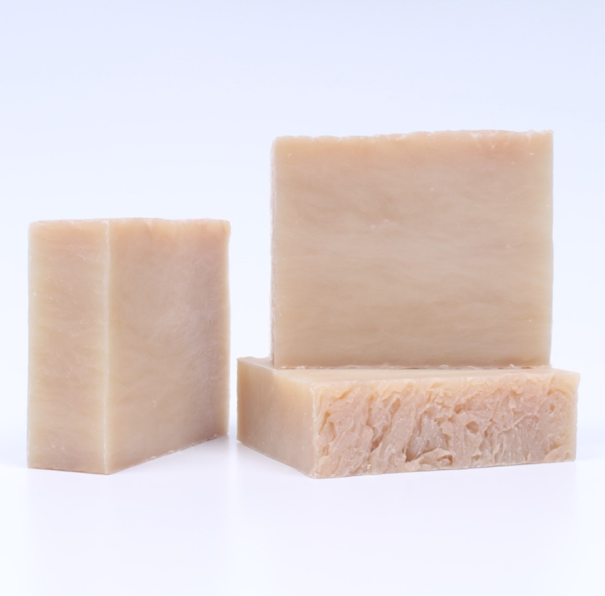 Three bars of beige soap on a white background