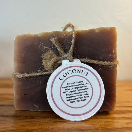 Bar of coconut soap with a label on a wooden surface