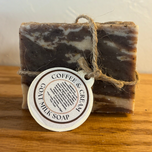 Bar of coffee and cream milk soap with a label on a wooden surface