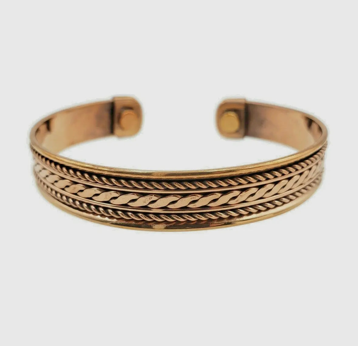 copper bracelet with braided design on a white background