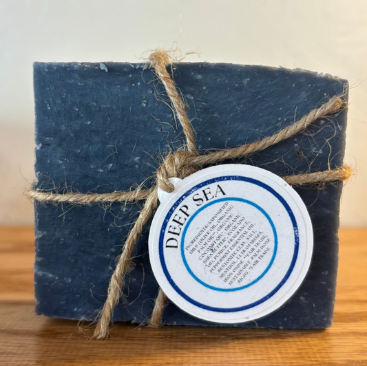 Bar of soap labeled 'Deep Sea' tied with twine on a wooden surface