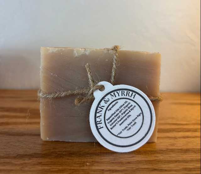 Bar of soap with a 'Frank & Myrrh' label on a wooden surface