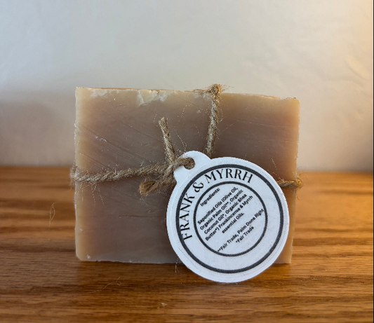 Bar of soap with a 'Frank & Myrrh' label on a wooden surface
