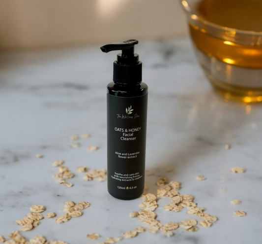 Black facial cleanser bottle with oats on a marble surface