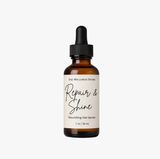 Brown glass bottle with black dropper cap labeled ‘The Wellness Store Repair & Shine Nourishing Hair Serum, 1 oz / 30 mL.’ The cream‑colored label features black text and minimalist design, representing a premium hair care product that repairs and adds shine.