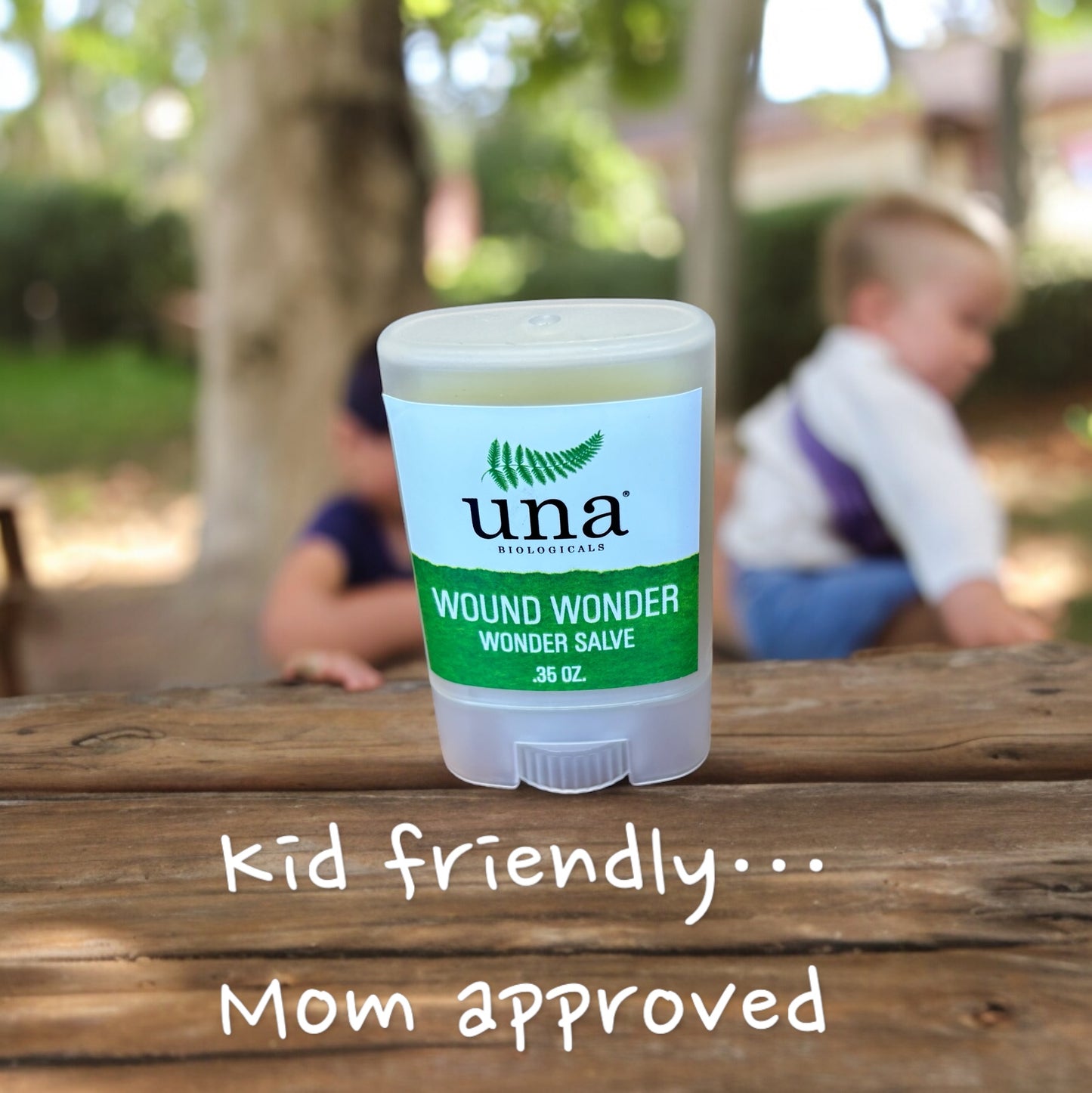 Wound wonder wonder salve  on a wooden table with kids blurred in the backbround