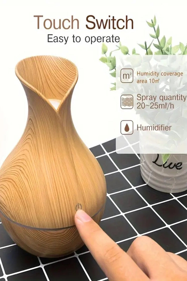 Wooden diffuser with a touch switch on a tiled surface, featuring text saying humidity coverage 10' area, pray 20-25ml/h, Humidifier.